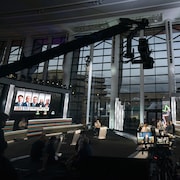 Un studio télé aménagé dans une immense salle. Sur un écran, les cinq chefs qui participent au débat.