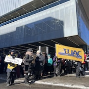 Des employés en grève manifestent devant la bibliothèque Gabrielle-Roy lors d’une froide journée d’hiver.
