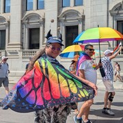 Des participants au défilé avec des drapeaux LGBTQ+.