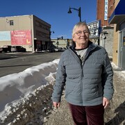 Une femme debout près de la route.
