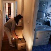 Une femme déplace des boîtes dans son appartement.