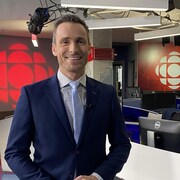Dans la salle de nouvelles de la station de Québec, Pascal Poinlane sourit à la caméra. 