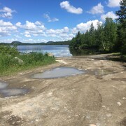 Un chemin au bord de l'eau qui mène à une descente de bateaux.