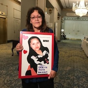 Diana Bigeagle tient une pancarte avec le portrait de sa fille disparue.