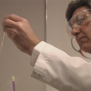 On voit le Dr Bernard Barwin en train de faire des tests de laboratoire à son ancienne clinique de fertilité.