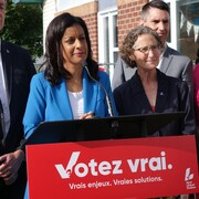 La cheffe du Parti libéral du Québec au lutrin, accompagnée de candidats, lors d'un point de presse électoral