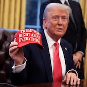 Donald Trump montre une casquette où il est écrit: «Trump avait raison sur tout».