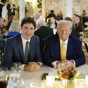 Justin Trudeau assis à côté de Donald Trump. 