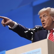 Donald Trump pointe du doigt une personne dans la foule.