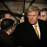 Trois hommes discutent ensemble.