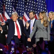 Donald Trump sur une scène, avec sa famille, alors qu'il pointe quelqu'un dans la foule.