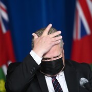 Le premier ministre de l'Ontario, Doug Ford, se touche le front lors d'une conférence de presse.