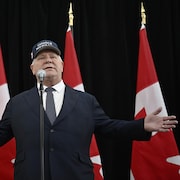 Le premier ministre de l'Ontario, Doug Ford, est coiffé d'une casquette qui porte la mention « Le Canada n'est pas à vendre ».