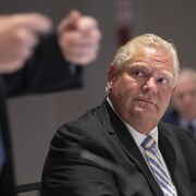 Le premier ministre Doug Ford écoute son homologue François Legault lors d'un sommet entre les deux provinces à Mississauga, en Ontario.