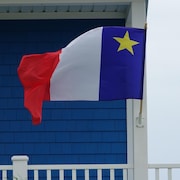 Un drapeau acadien flotte au vent, fixé à une maison située sur l'île du Havre Aubert, dans l'archipel.