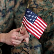 Plan rapproché d'un petit drapeau américain tenu par un soldat.