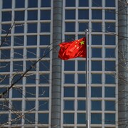 Un drapeau chinois devant un édifice.