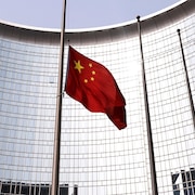 Le drapeau national de la Chine est placé en berne devant un édifice gouvernemental.