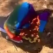 Le drapeau est parterre à moitié brûlé.  