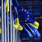 Des drapeaux de l'Union européenne et de l'Ukraine flottent au vent.