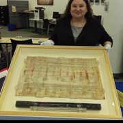 Paula Daigle, bibliothécaire à l'Université des Premières Nations du Canada, montre l'original du Traité 8, datant de 1899.
