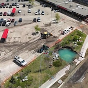 Image aérienne d'un stationnement où se trouve un gros trou.