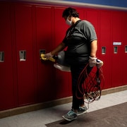 Un concierge nettoie en soirée une rangée de casiers d'une école primaire de West Bloomfield, au Michigan, le 9 septembre 2020.