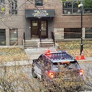 Une auto de police devant l'entrée de l'école.