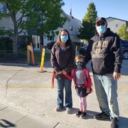 Un couple qui accompagne une petite fille à l’école.