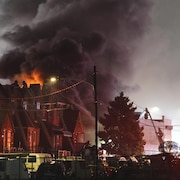 Des flammes émergent derrière des maisons dans un quartier résidentiel de Philadelphie, le 31 janvier 2025.