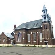 Le côté d'une église en briques brunes.