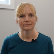 La médecin pose pour une photo dans une salle de sa clinique.