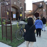 Des gens font la file devant le bureau de vote de la circonscription de Davenport, à Toronto, pour exercer leur droit de vote.