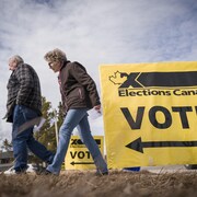 Des électeurs au moment d'arriver pour voter par anticipation aux élections fédérales de 2025 à Carstairs, en Alberta, le vendredi 18 avril 2025.