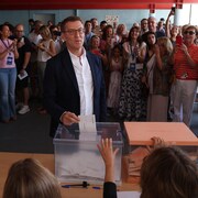 Alberto Núñez Feijóo dépose son vote dans une boîte de scrutin en présence de dizaines d'Espagnols.