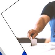 Une personne masqué dépose son bulletin de vote dans une boîte