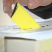 Un homme dépose un bulletin de vote dans une boîte de scrutin.