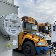 Un compteur hydroélectrique devant des autobus scolaires.
