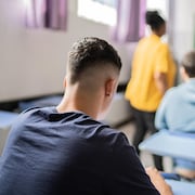 Un adolescent dans une salle de classe.