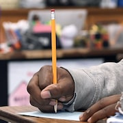 Main d'un enfant qui tient un crayon. 