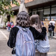 Deux adolescentes devant une école secondaire.