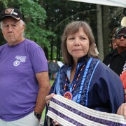 Ellen Gabriel, entourée d'aînés, tient un Wampum. 