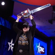 Un homme brandissant une tronçonneuse.