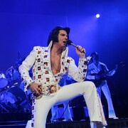 Martin Fontaine déguisé en Elvis Presley en train de chanter sur une scène.