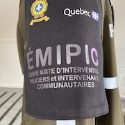 Le logo de l'équipe d'intervention sur un brassard de l'habit d'un policier.