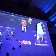 Emmanuel Macron sur un écran géant lors d'un rassemblement de son parti Renaissance.