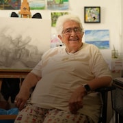 Lucille Proulx est assise dans son atelier, devant son chevalet avec une œuvre en cours, à Victoria, en Colombie-Britannique.