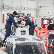 Des étudiants font la maintenance d'un hélicoptère