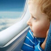 Un enfant regarde par le hublot d'un avion.