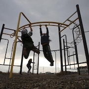 Des enfants de la Première Nation Attawapiskat dans le nord de l'Ontario s'amusent dans une structure de jeu. 